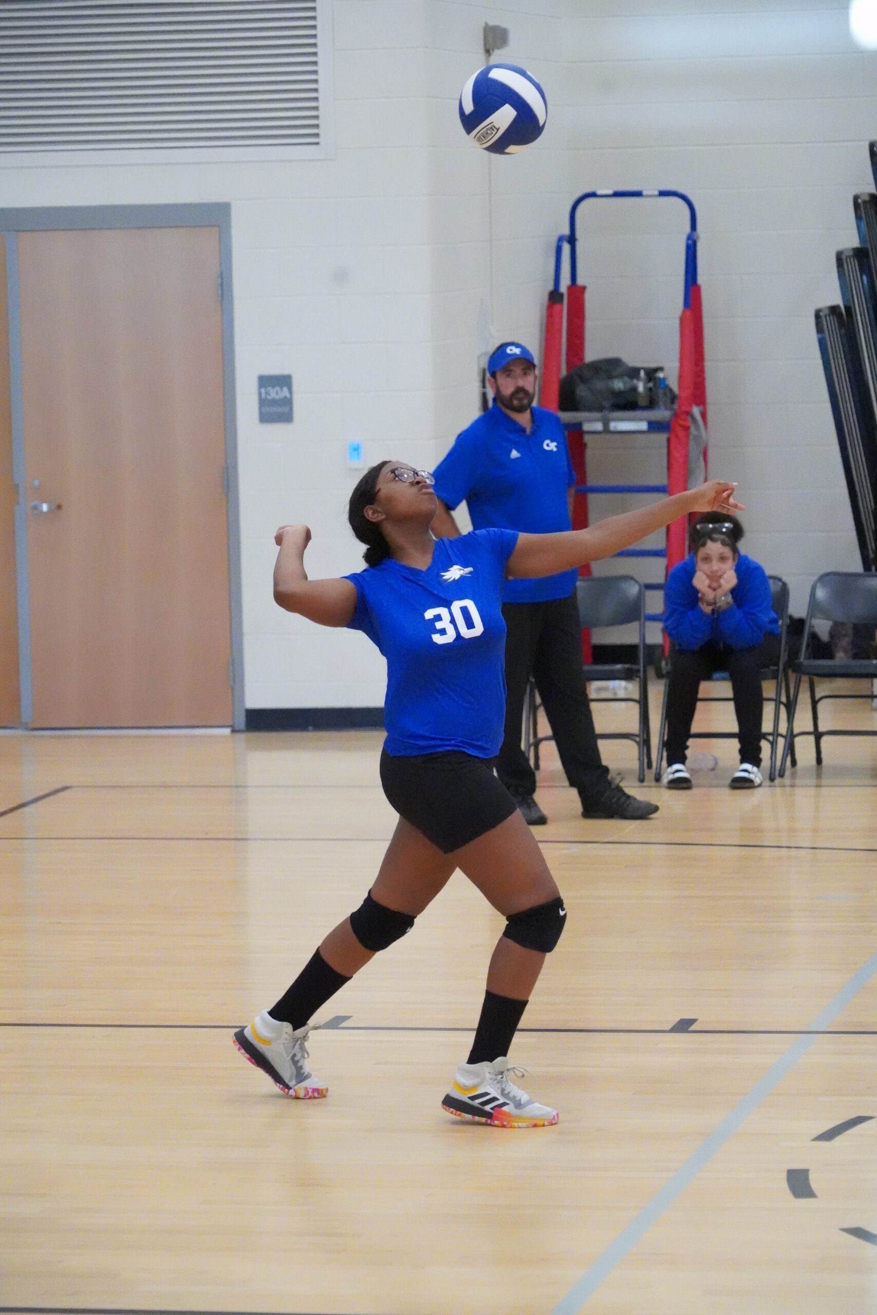 Player serving up the ball at a Grasso Tech Volleyball Game