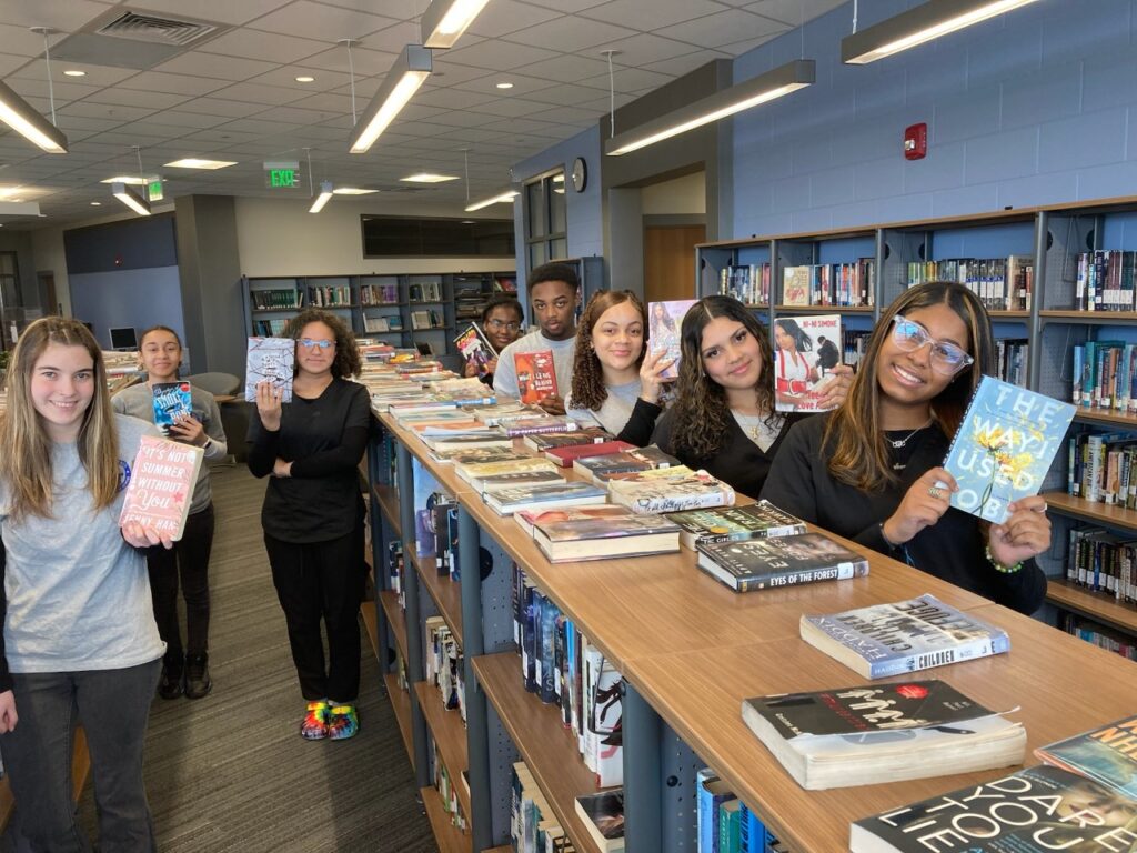 Grasso Tech Students showing off their book selections from the school library.