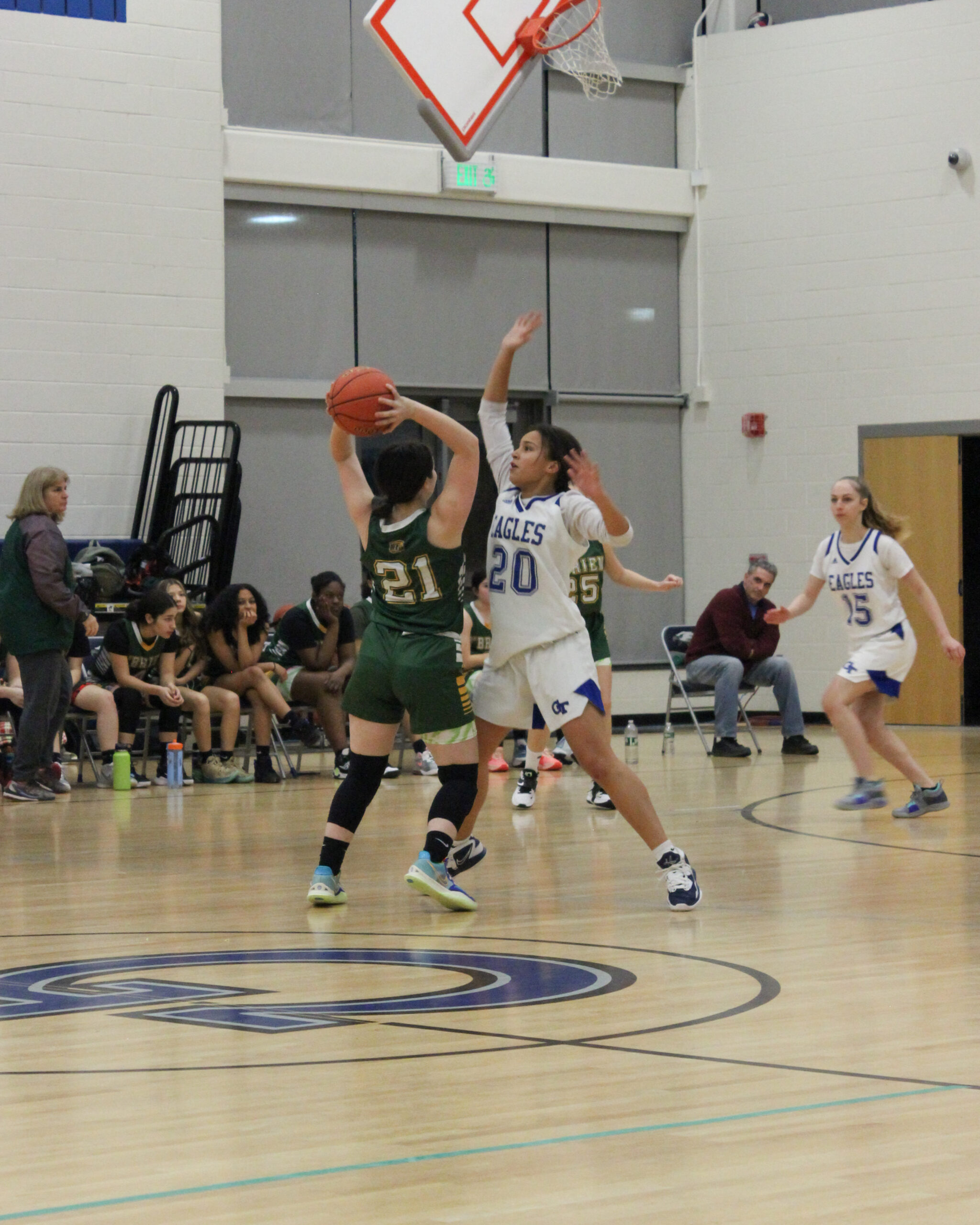 Action shot of a player playing defense in a Grasso Tech Girls' Basketball game.
